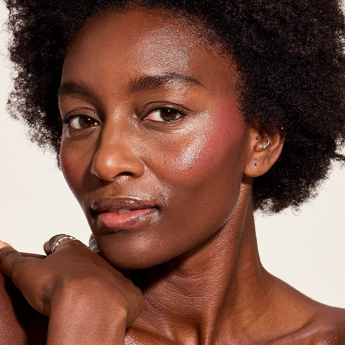 DEEPCHERRYBLUSH-1 Deep skin woman with deep cherry blush against a plain background